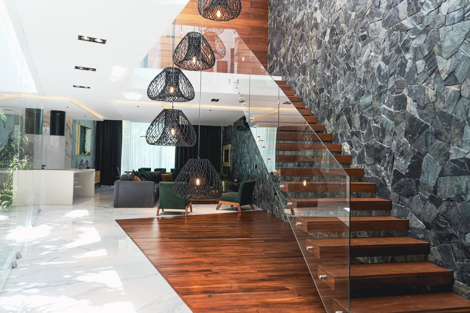 Casa 223 · Club Real — escalera flotante contra el muro de piedra